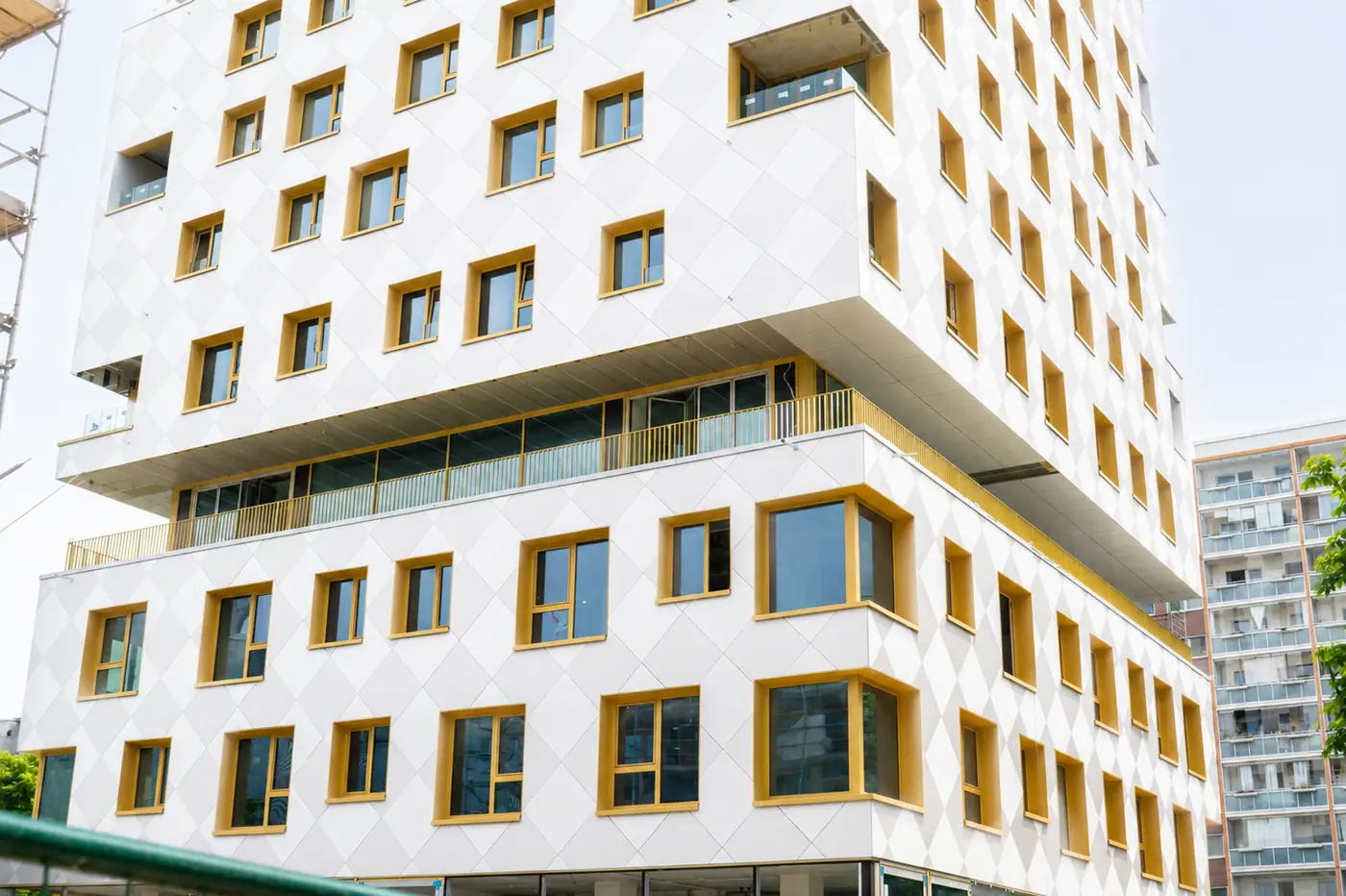 Weiße Neubaufassade mit gelb gerahmten Fenstern in Berlin nach der Baufeinreinigung