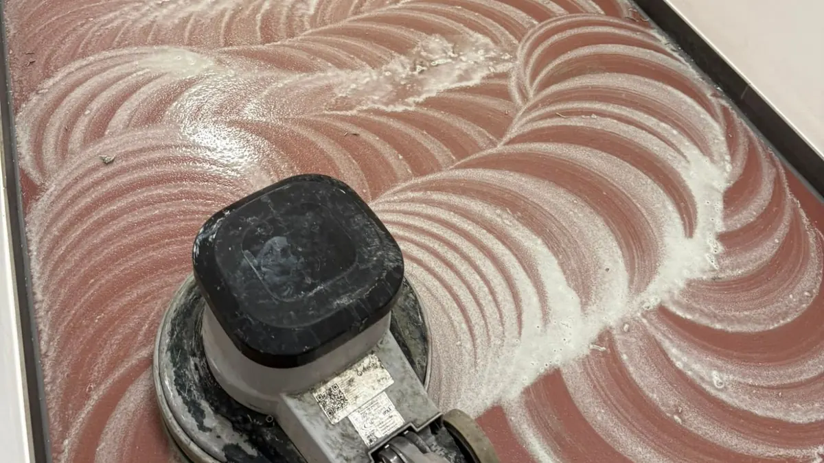 Einscheibenmaschine bei der Grundreinigung eines roten Epoxidbodens im Treppenhaus