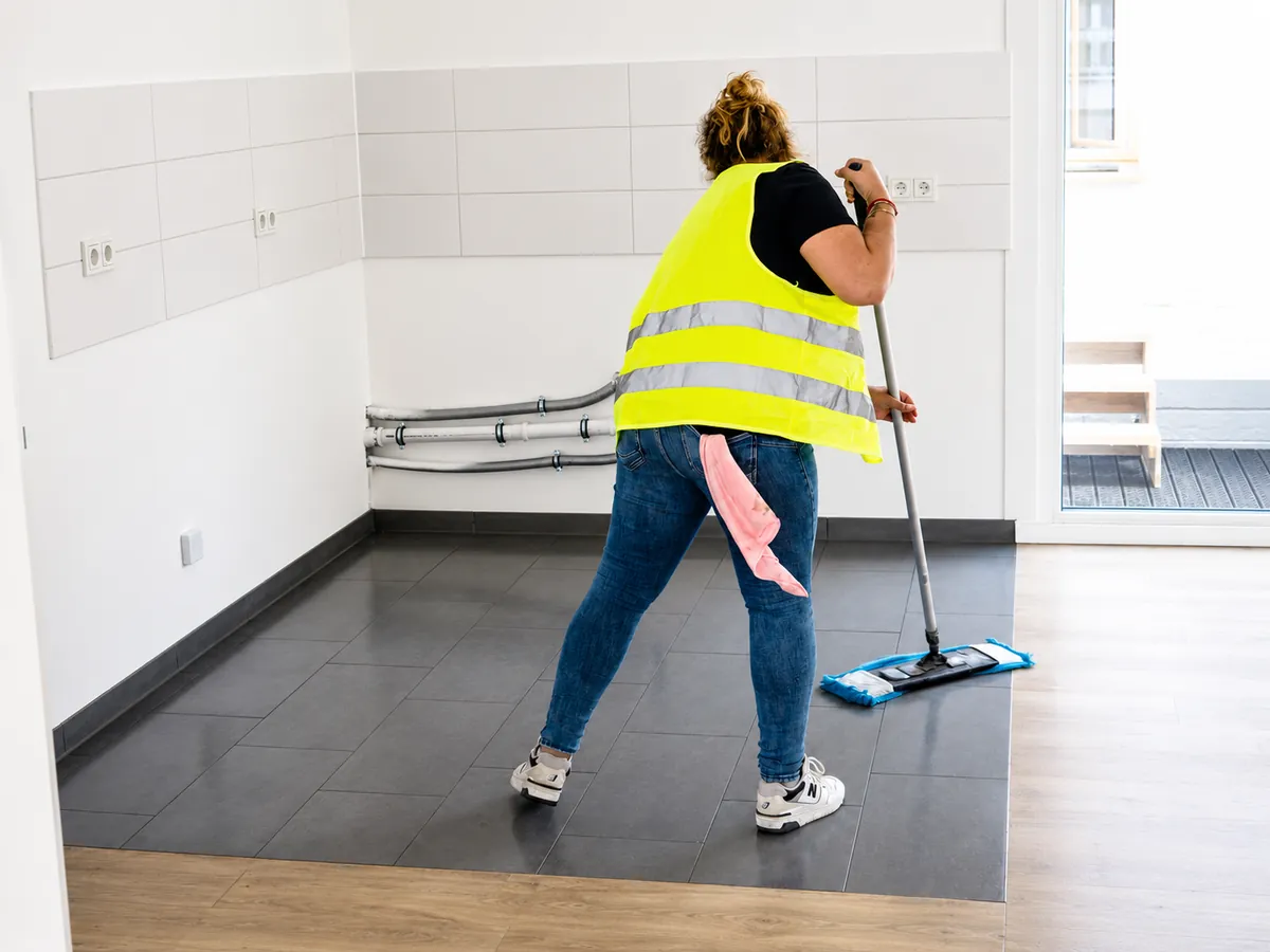 ELMA-Mitarbeiterin wischt den Boden einer leeren Wohnung