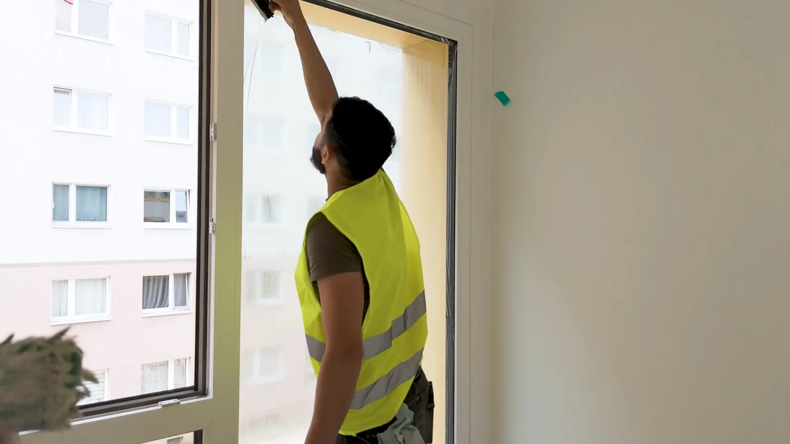 ELMA-Mitarbeiter reinigt bei der Bauendreinigung einen Fensterrahmen in einem Berliner Neubau