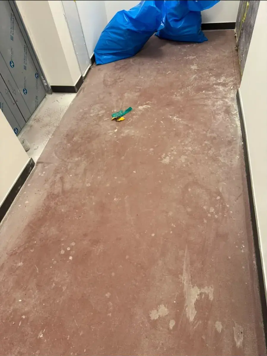 Vorher: roter Epoxidboden im Treppenhaus mit Bauschmutz, Staub und Farbresten